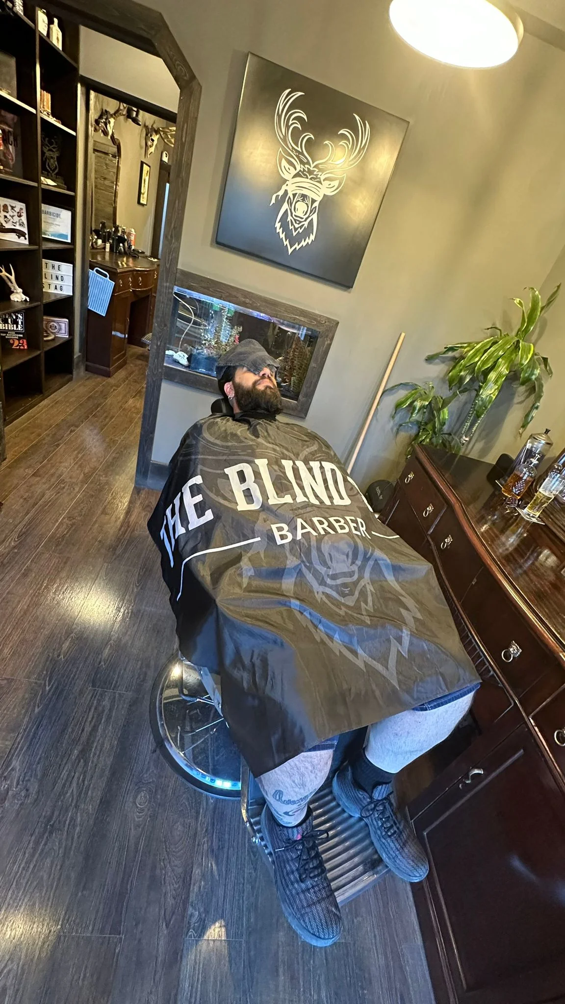 Barber cape with logo and text in a barber shop setting.
