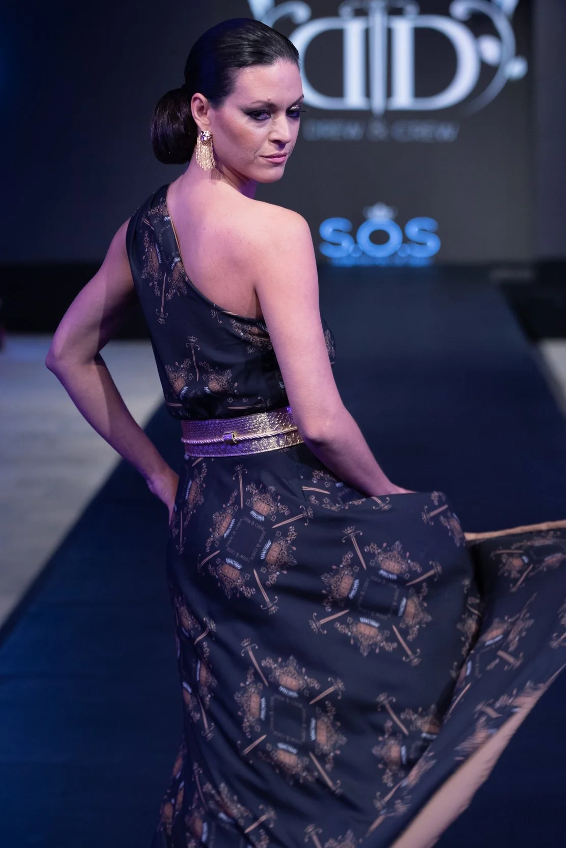 Model wearing a custom printed fabric dress on a runway, showcasing fabric printing service.