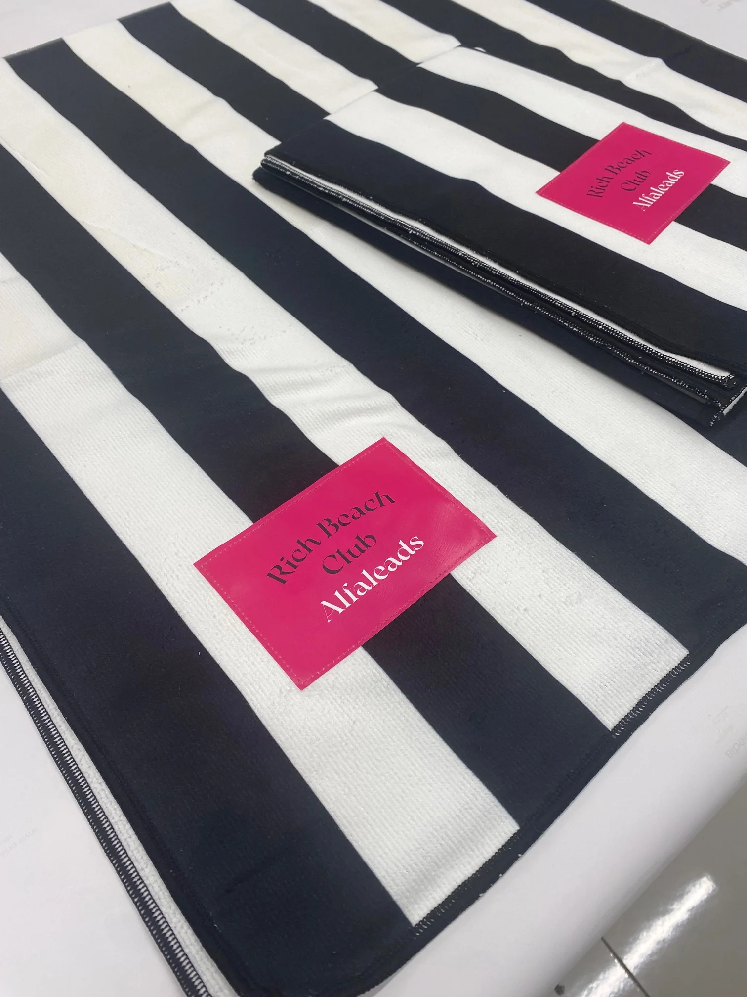 Custom beach towel with sublimation printing and pink label.