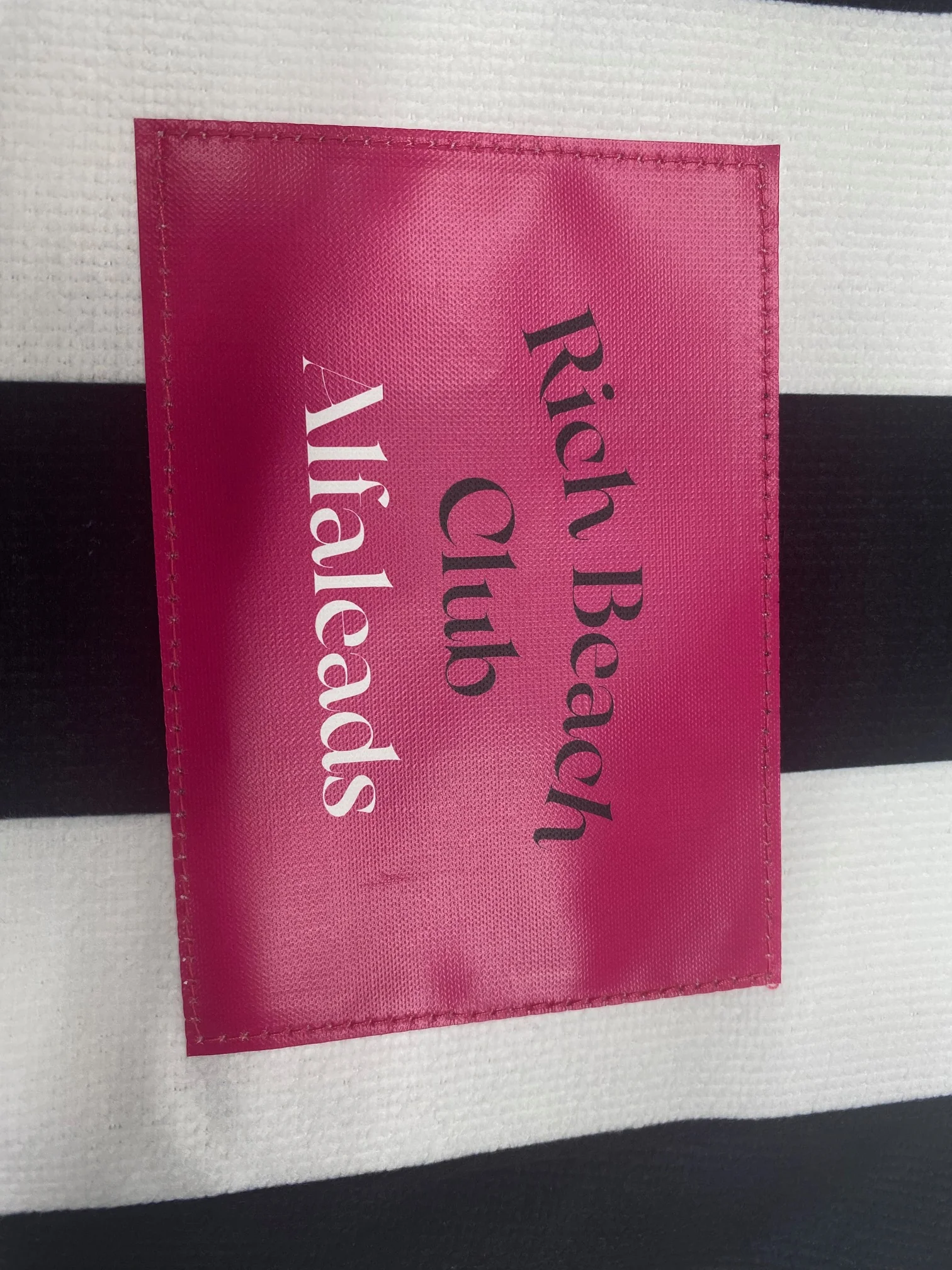 Custom beach towel with Rich Beach Club label, showcasing sublimation printing.