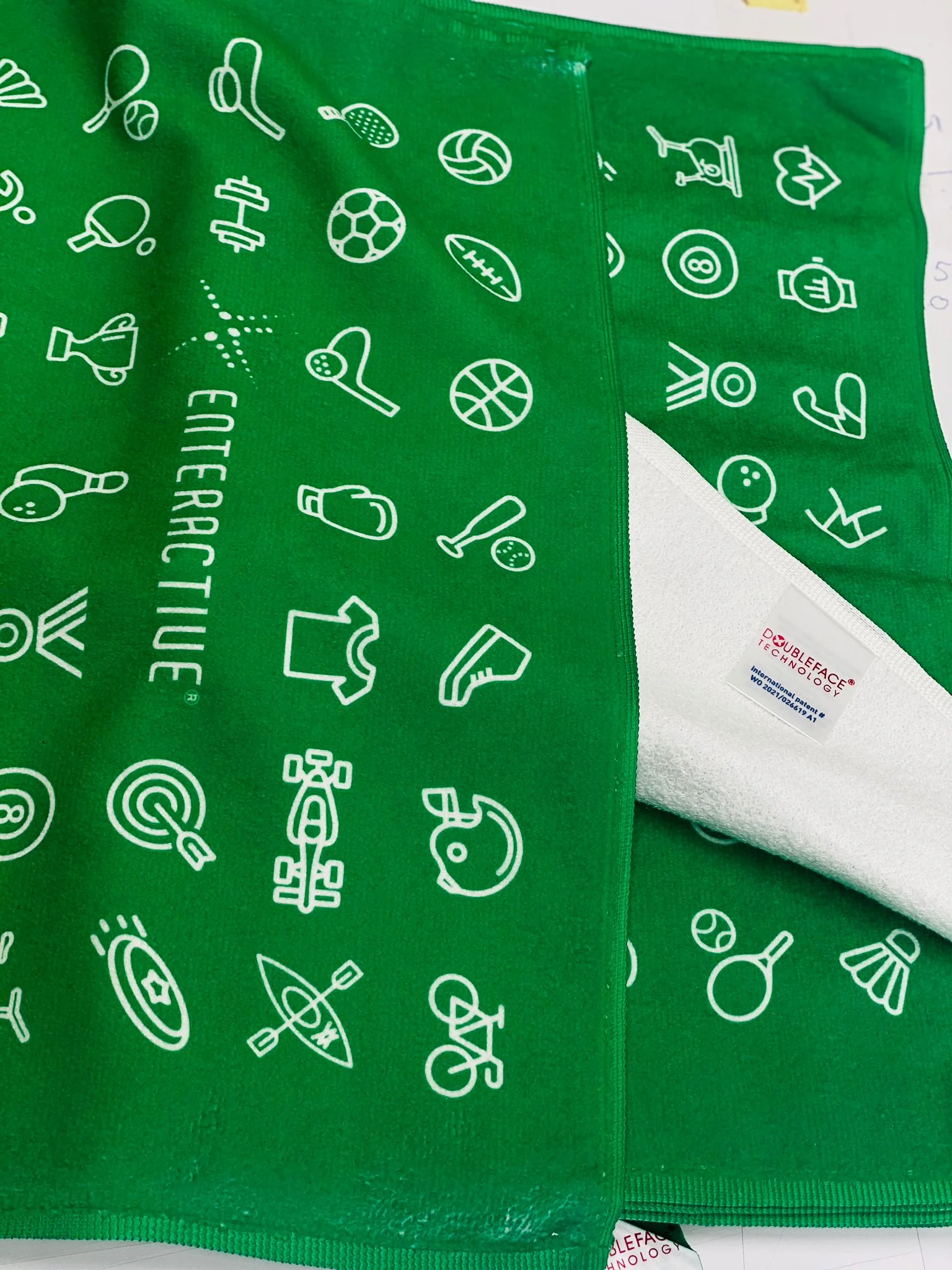 Green towel with white icons and text, featuring 'Enteractive'.