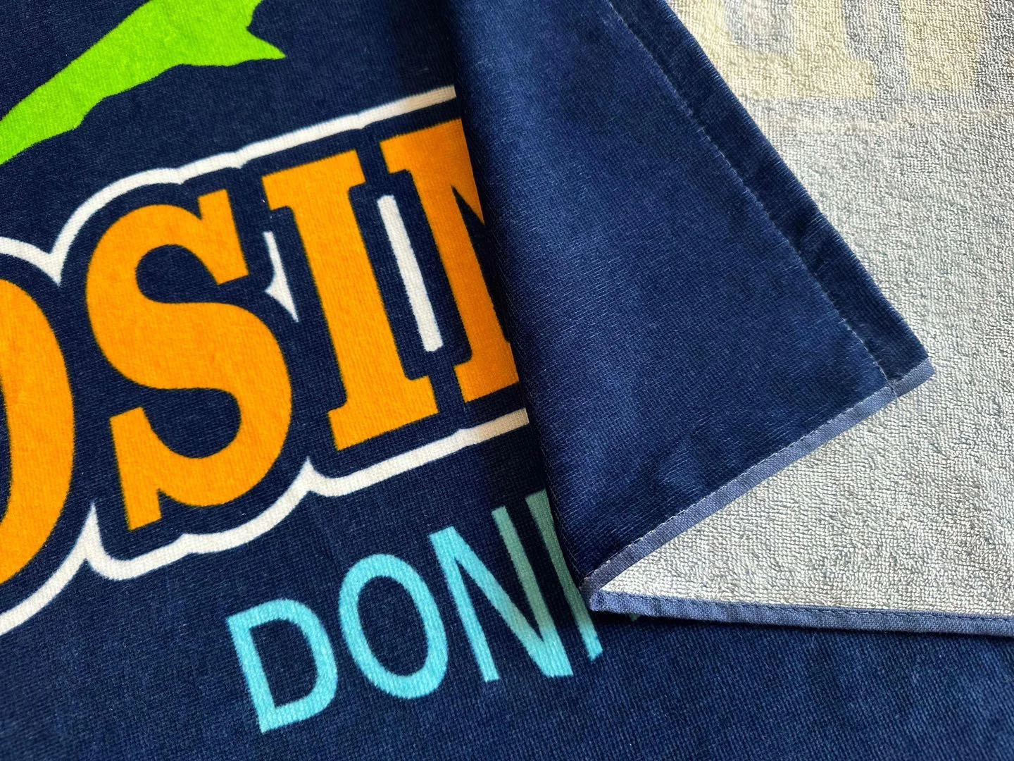 Cotton custom towel with vibrant printed design for promotional use.