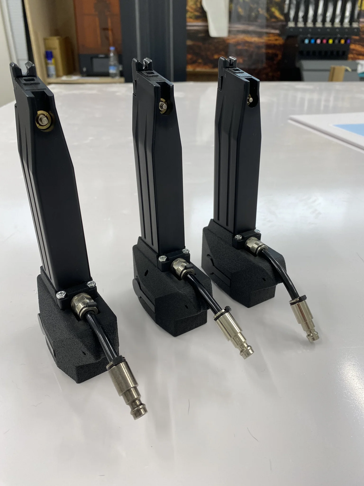 Three industrial nozzles with metal fittings on a white surface.