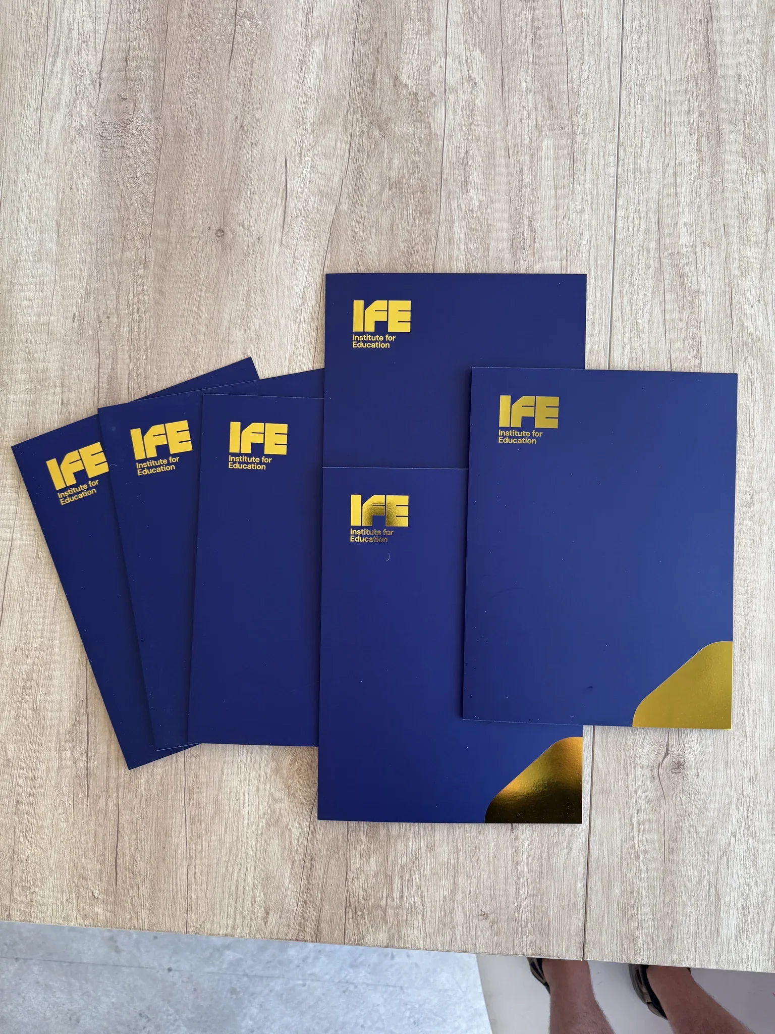 Digital printing of blue brochures with gold IFE logo.
