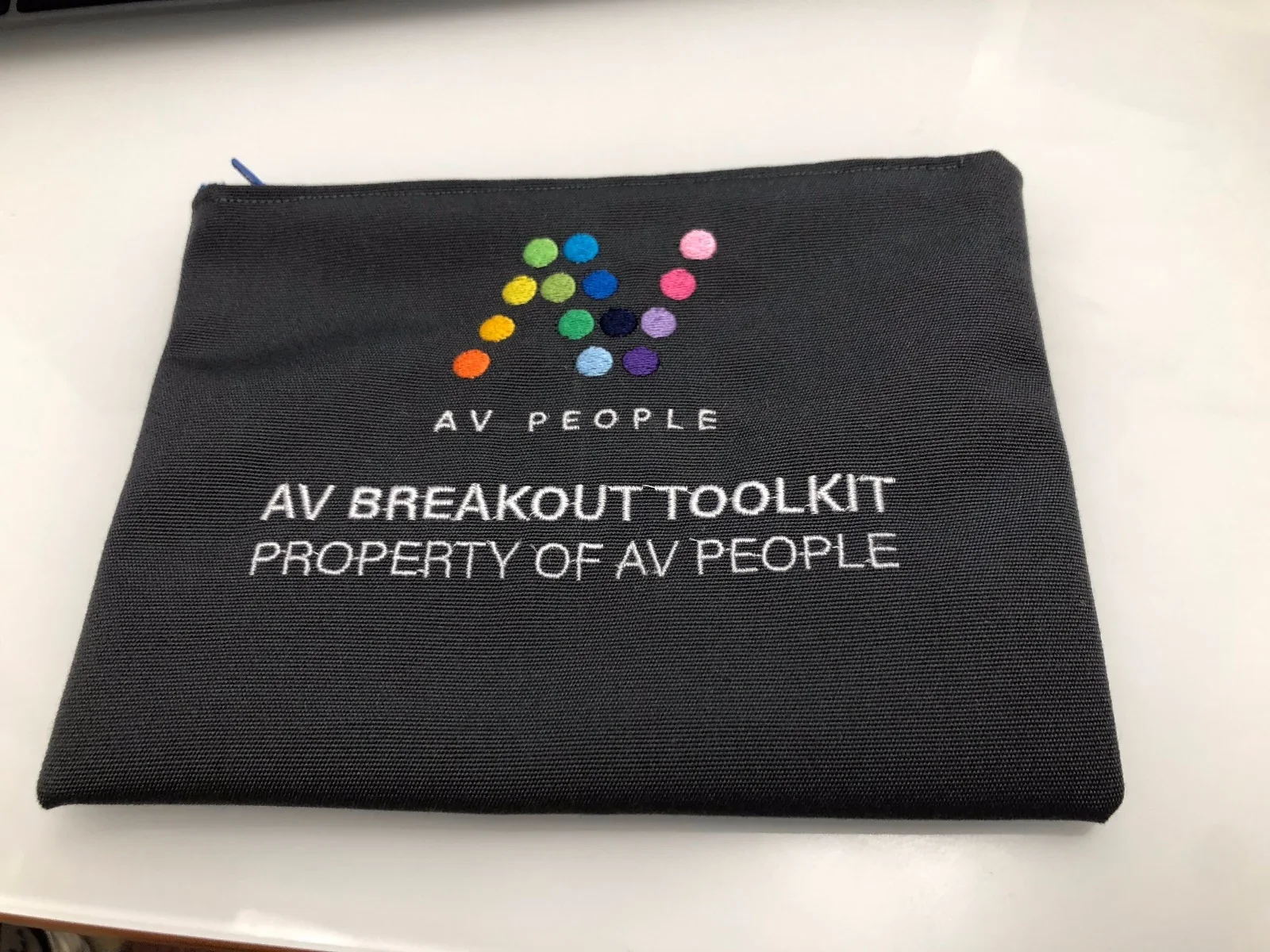Grey pouch with custom embroidery for AV People.