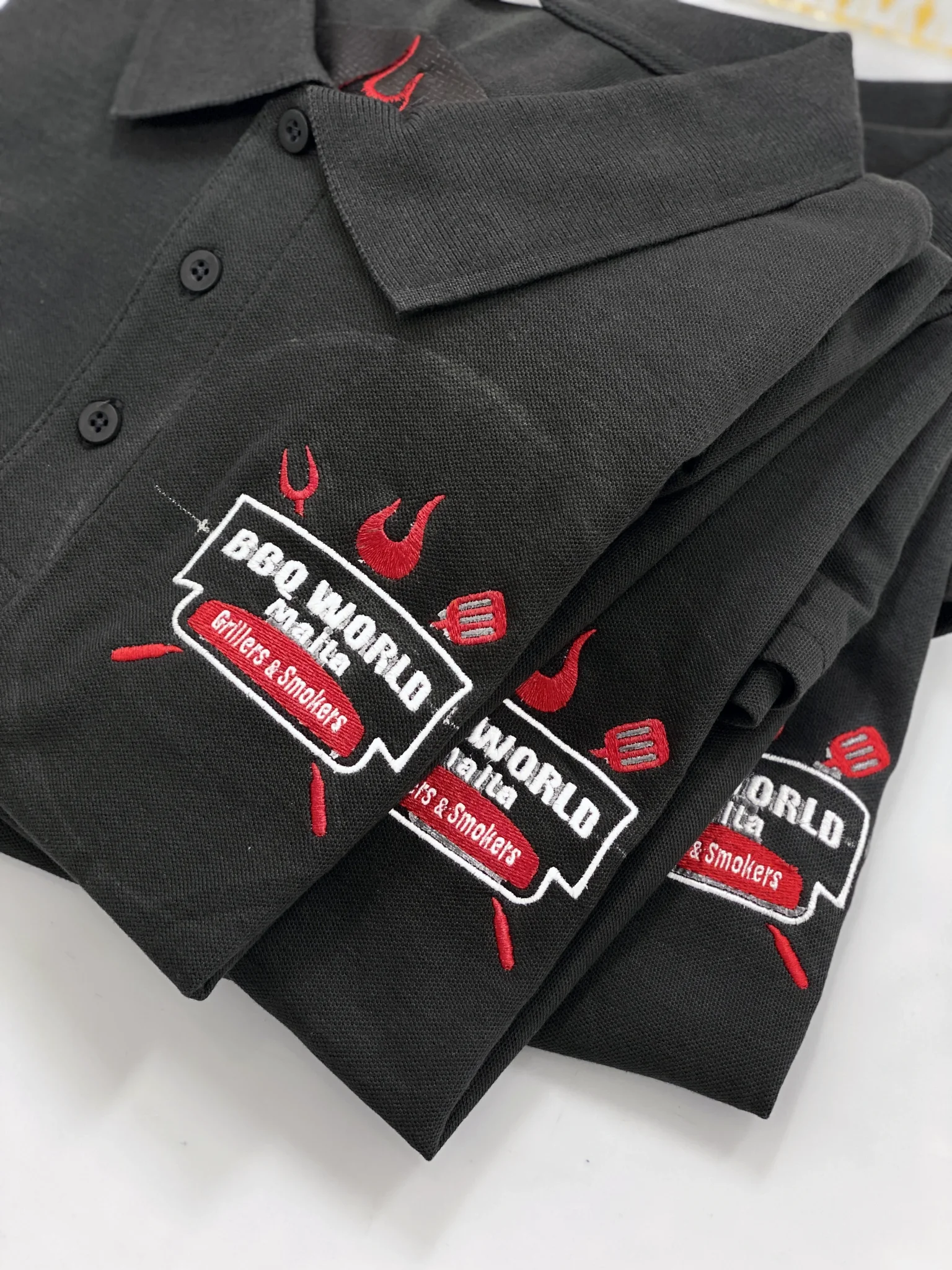 Embroidered polo shirts with logos for workwear branding.