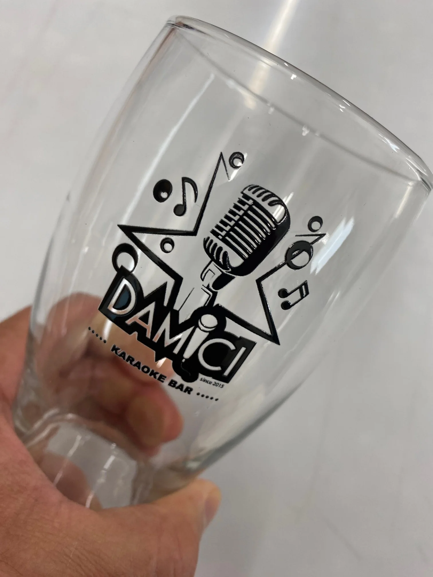 Beer glass printed with Damici Karaoke Bar logo, custom glassware printing.