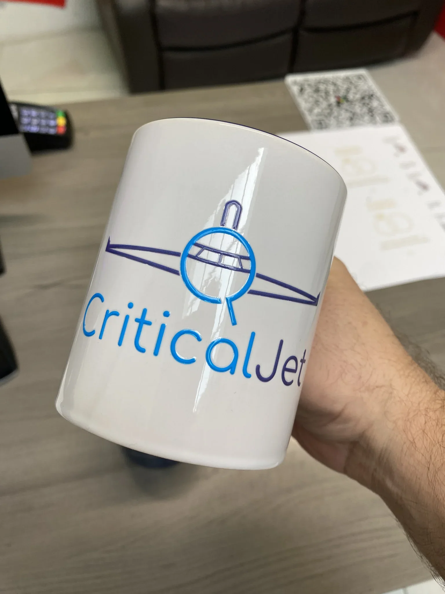 White ceramic mug printed with CriticalJet aviation logo for corporate branding.